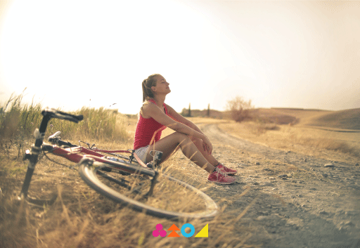 Mujer disfrutando del paisaje en Marina del Arrayán junto a su bicicleta al atardecer.