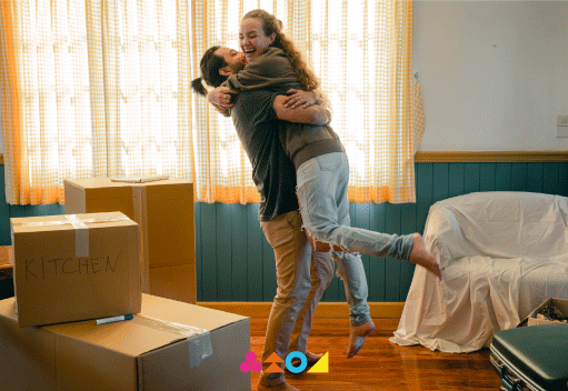 Pareja feliz desempacando en su nuevo hogar en el Edificio Santa Victoria